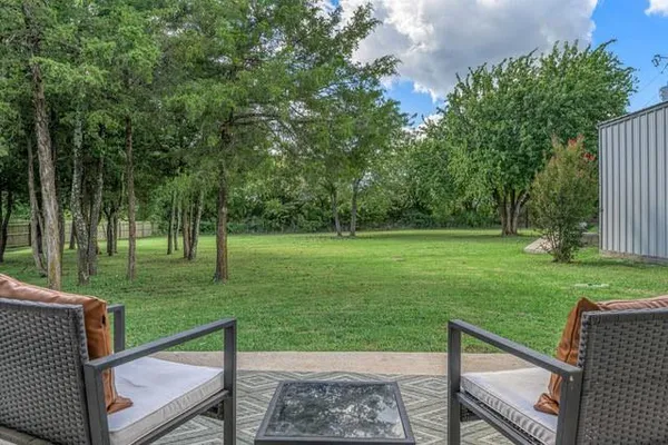 a view of a garden with trees in the background