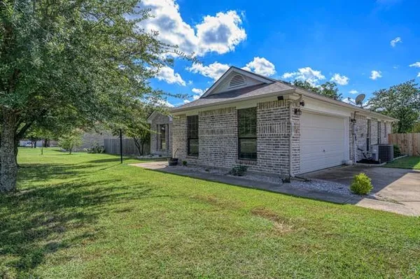 a view of a house with backyard and a tree