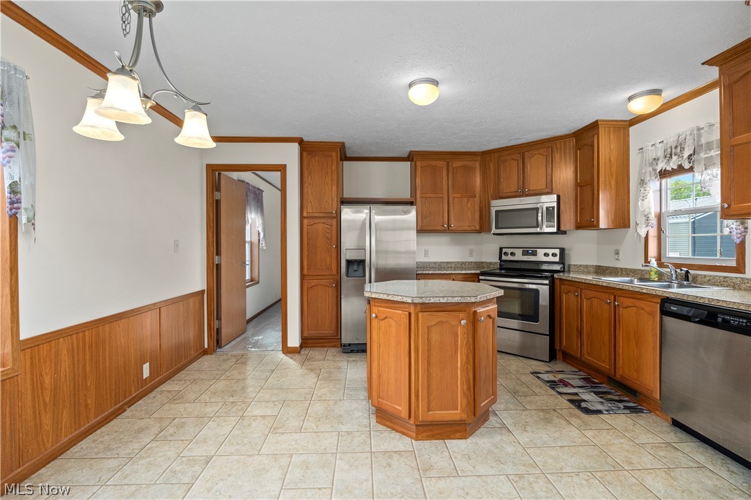35157 Center Ridge Road, Unit 92 North Ridgeville, OH 44039 - Photo 6 of 40 Tile flooring, wood-finish cabinetry, stainless steel appliances, central kitchen island with countertop, and wainscoting