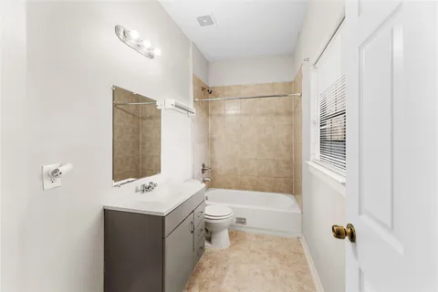 a bathroom with a bathtub shower sink mirror and toilet