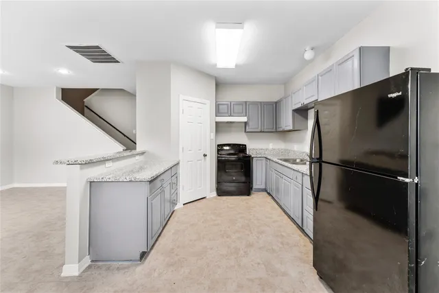 a kitchen with a refrigerator a sink and a oven
