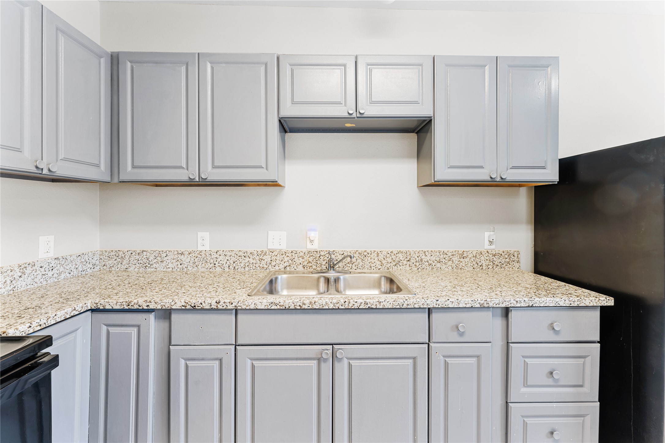 9610 Buffum Street, Unit B Houston, TX 77051 - Photo 6 of 25 a kitchen with granite countertop white cabinets and a sink