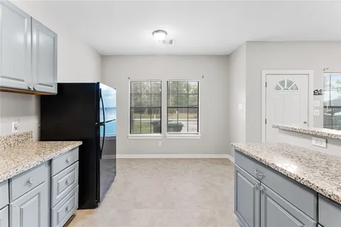 a kitchen with granite countertop a refrigerator and a sink