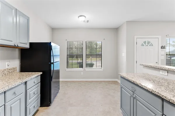 a kitchen with granite countertop a refrigerator and a sink