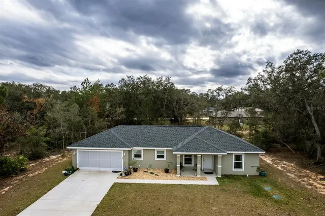 a aerial view of a house with a yard and basket ball court