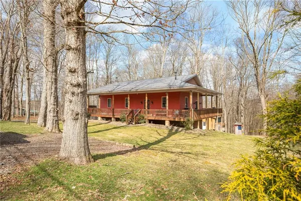 a view of a house with basket ball court and a yard