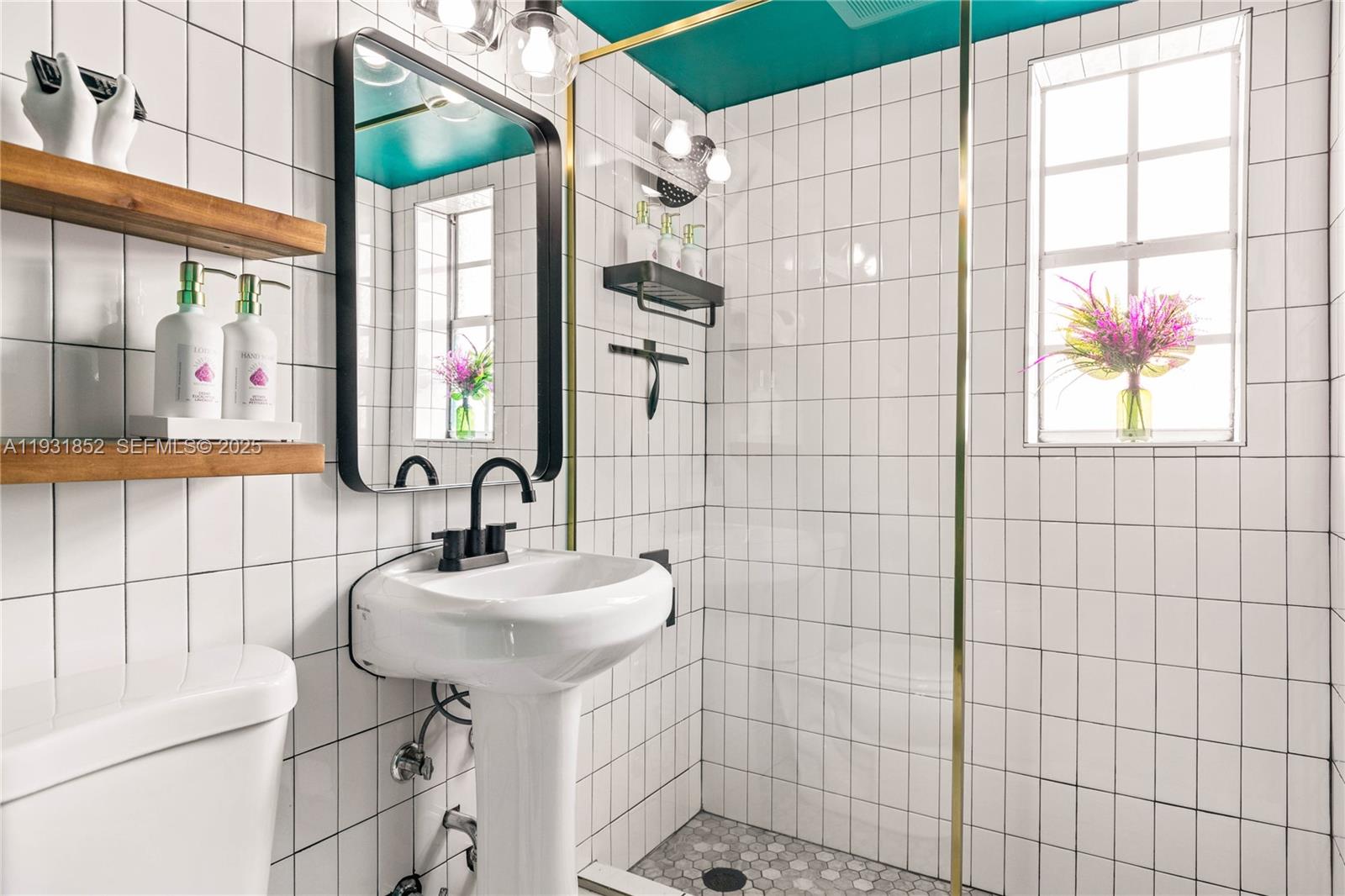 1007 Southeast 2nd Court, Unit 4 Fort Lauderdale, FL 33301 - Photo 14 of 15 a bathroom with a sink a mirror and shower