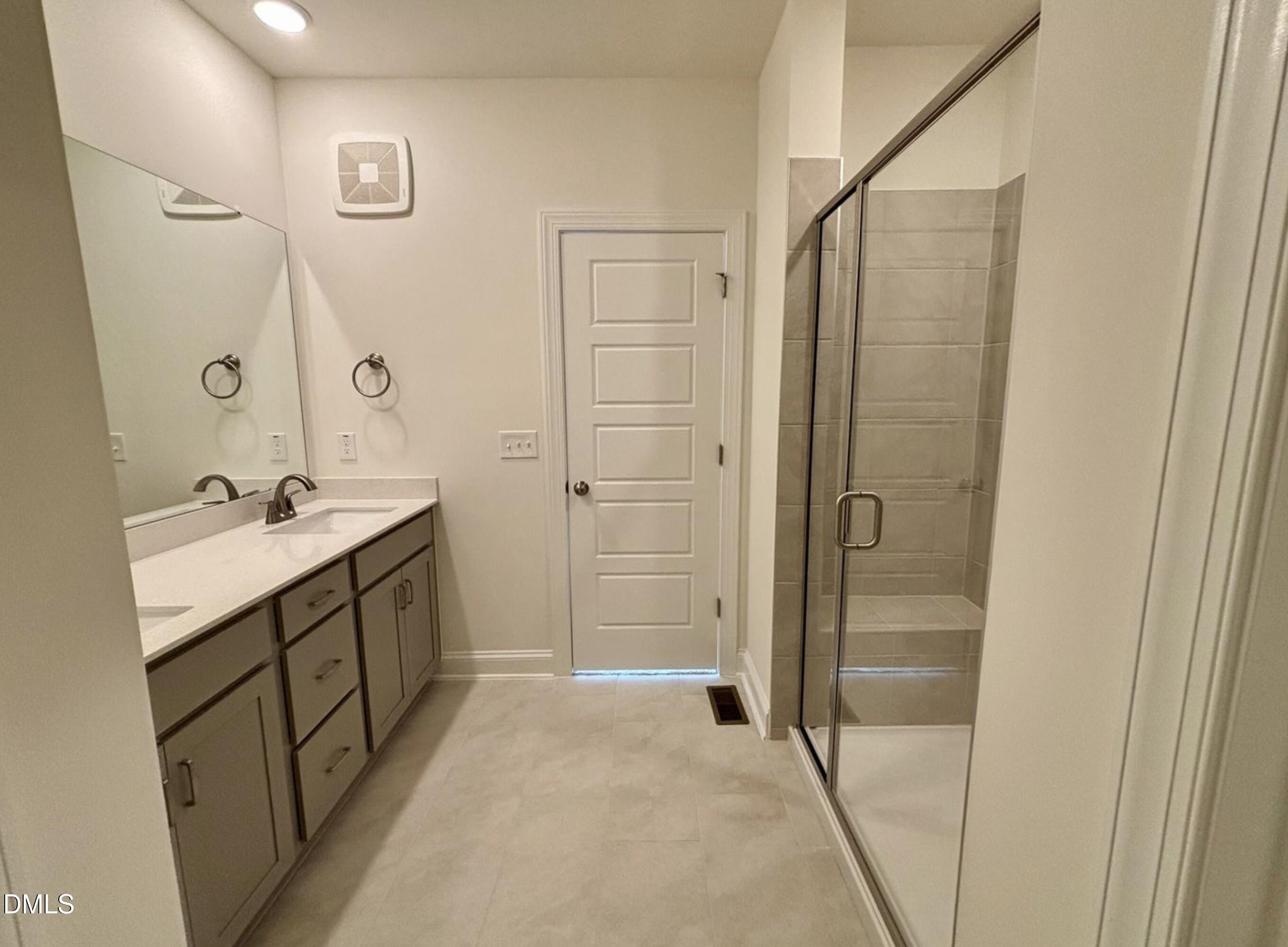 10533 Pleasant Br Drive, Unit 101 Raleigh, NC 27614 - Photo 17 of 27 a bathroom with a double vanity sink a toilet and shower