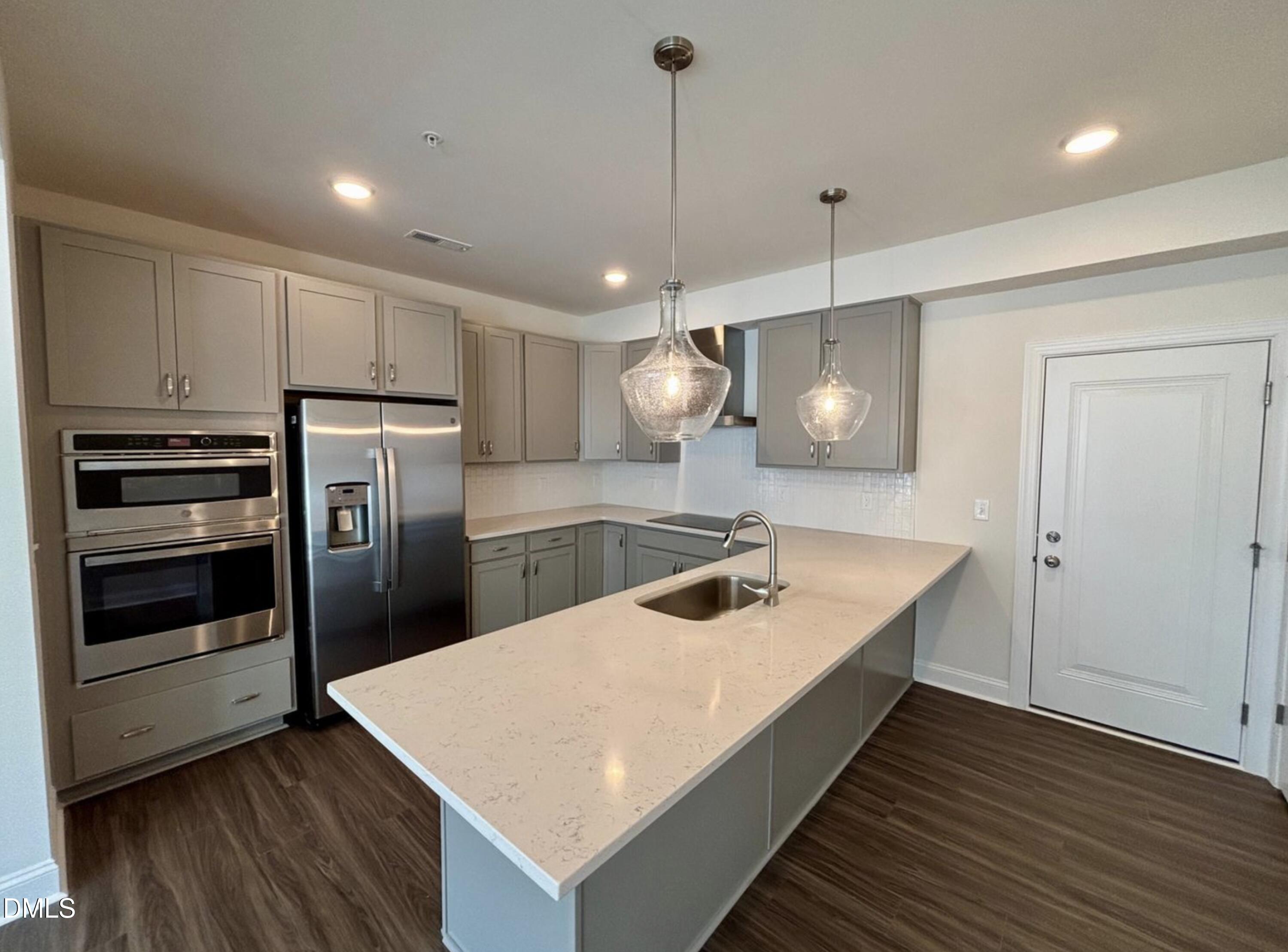 10533 Pleasant Br Drive, Unit 101 Raleigh, NC 27614 - Photo 5 of 27 a kitchen with kitchen island a sink stainless steel appliances and wooden floor