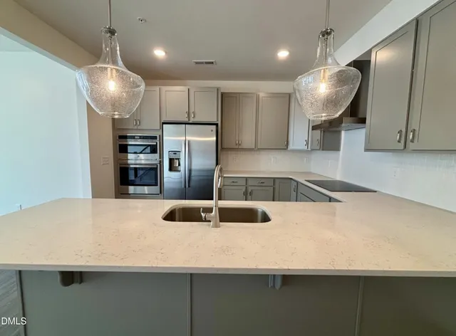 a kitchen with stainless steel appliances a refrigerator sink and microwave