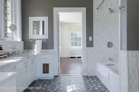 a bathroom with mirror sink and window