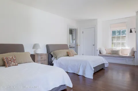 a bedroom with two beds and wooden floor