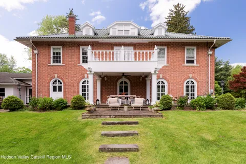 a view of a patio with table and chairs potted plants and large tree