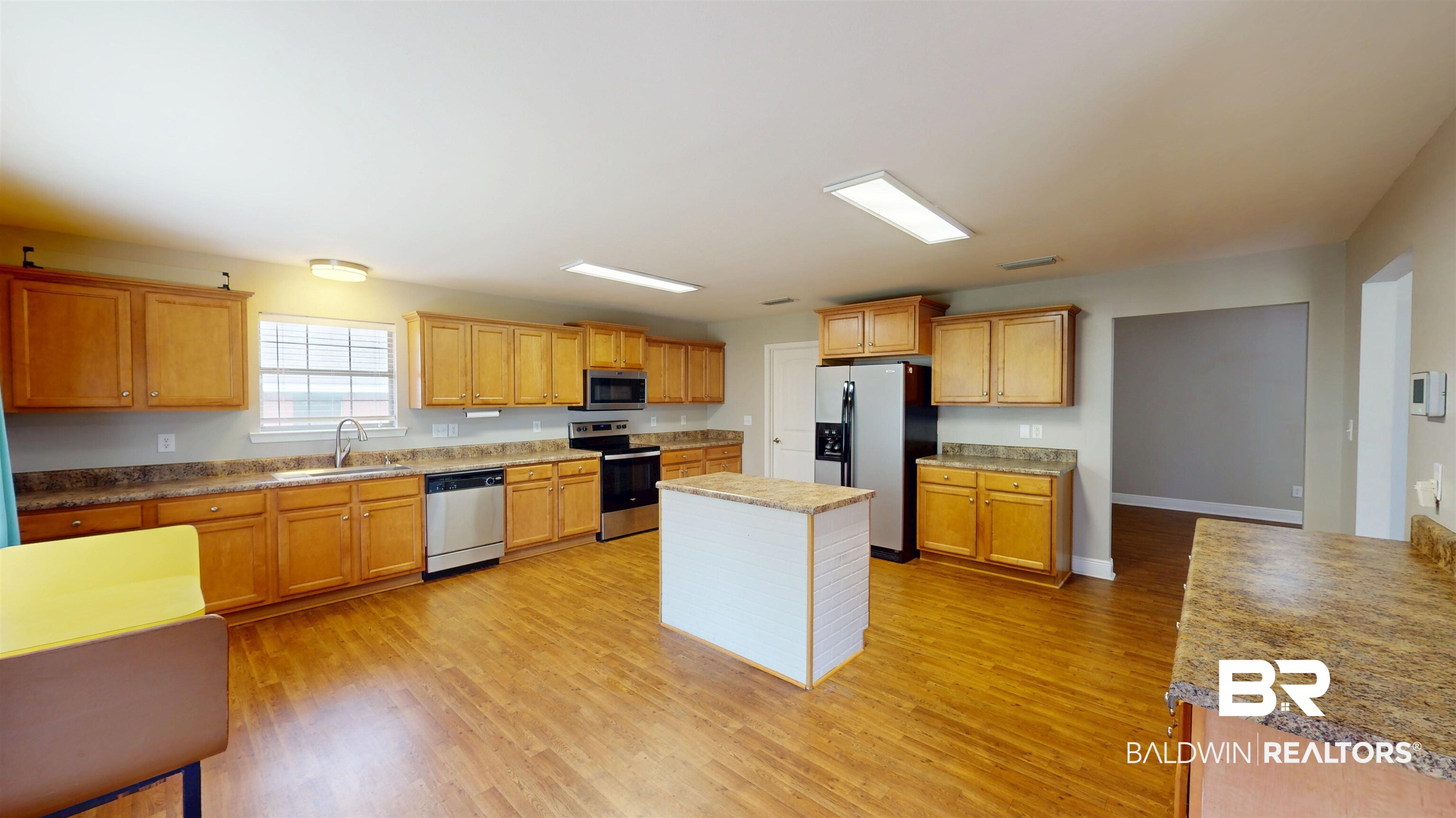 10753 Rigby Drive Mobile, AL 36695 - Photo 12 of 33 Kitchen with visible vents, light wood-style flooring, stainless steel appliances, a sink, and a center island