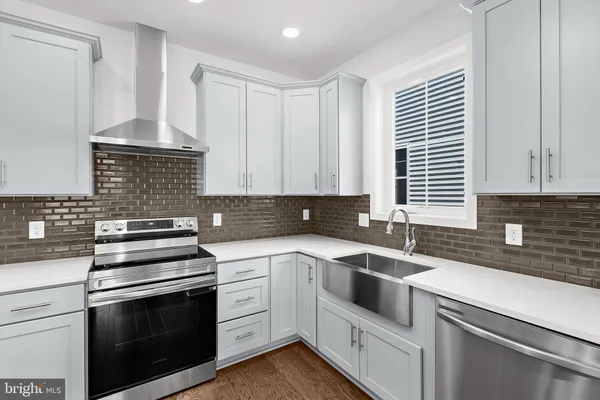 a kitchen with white cabinets stainless steel appliances and sink