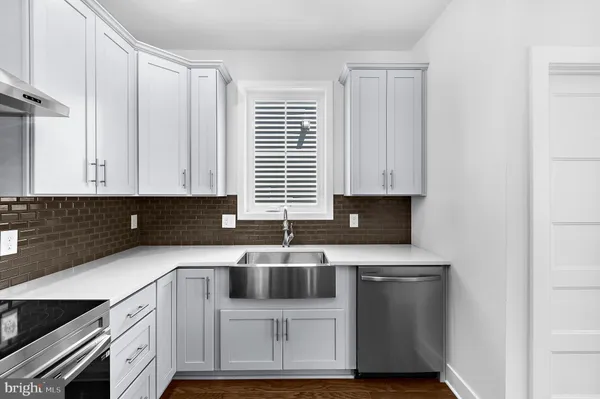 a kitchen with granite countertop a sink a stove and cabinets