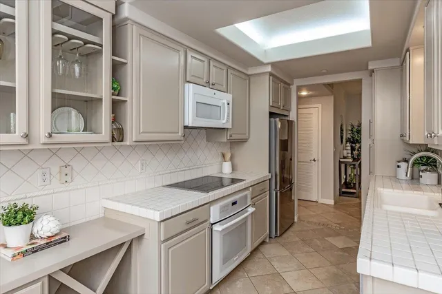 a kitchen with stainless steel appliances granite countertop a sink and a refrigerator