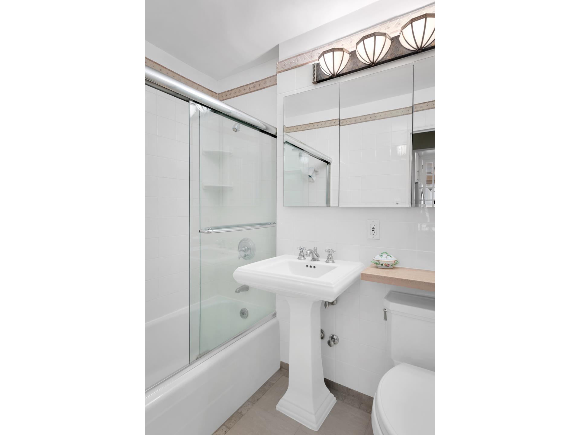 360 East 72nd Street, Unit C2205 Manhattan, NY 10021 - Photo 10 of 16 a bathroom with a sink toilet and a mirror