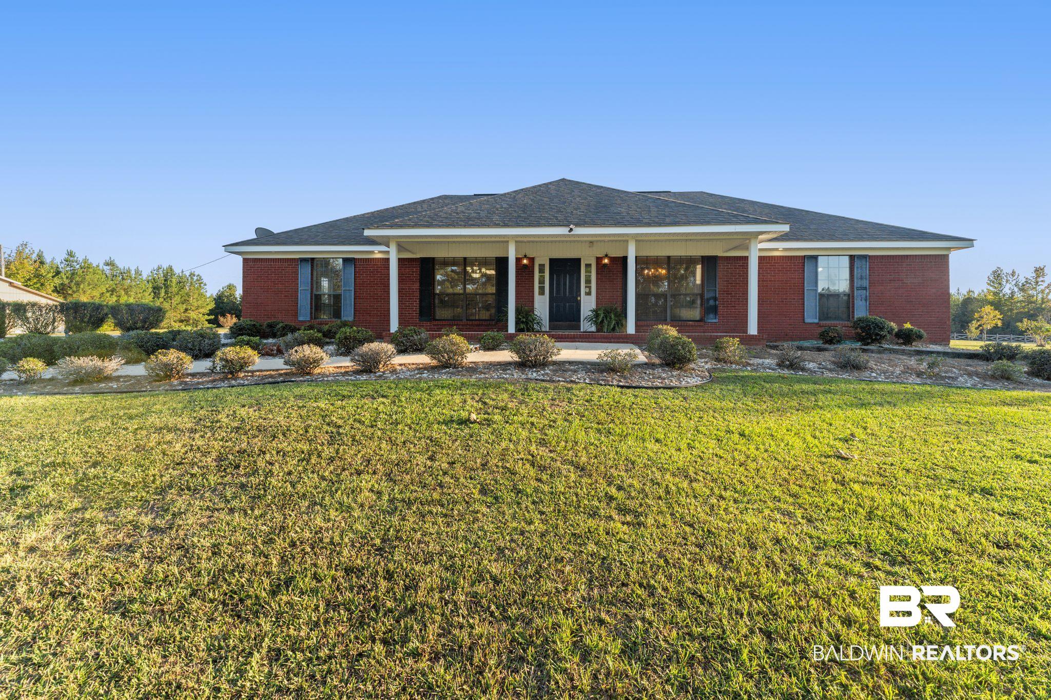 888 Mobile Cut-Off Road St. Stephens, AL 36569 - Photo 3 of 54 Ranch-style home with covered porch, brick siding, and a front lawn