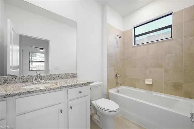 a bathroom with a granite countertop sink a toilet and a mirror