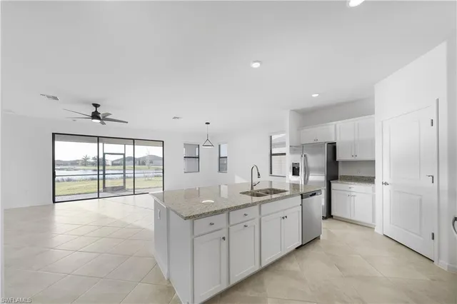 a kitchen with stainless steel appliances granite countertop a sink and a refrigerator