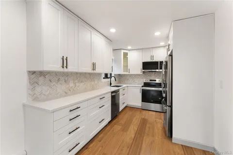 a kitchen with stainless steel appliances sink cabinets and wooden floor