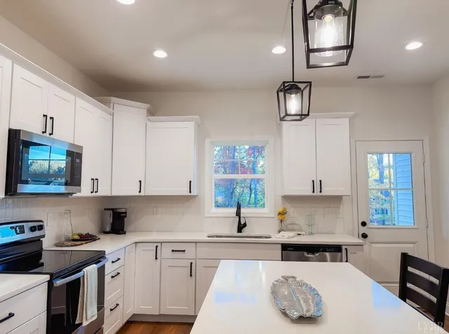 a kitchen with stainless steel appliances granite countertop a sink stove and cabinets