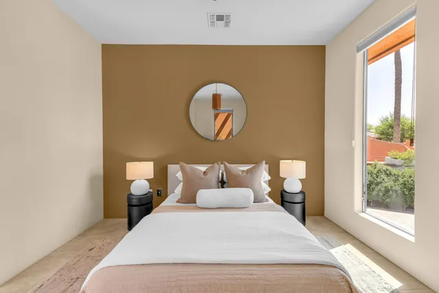 a bedroom with a bed and a painting on the wall