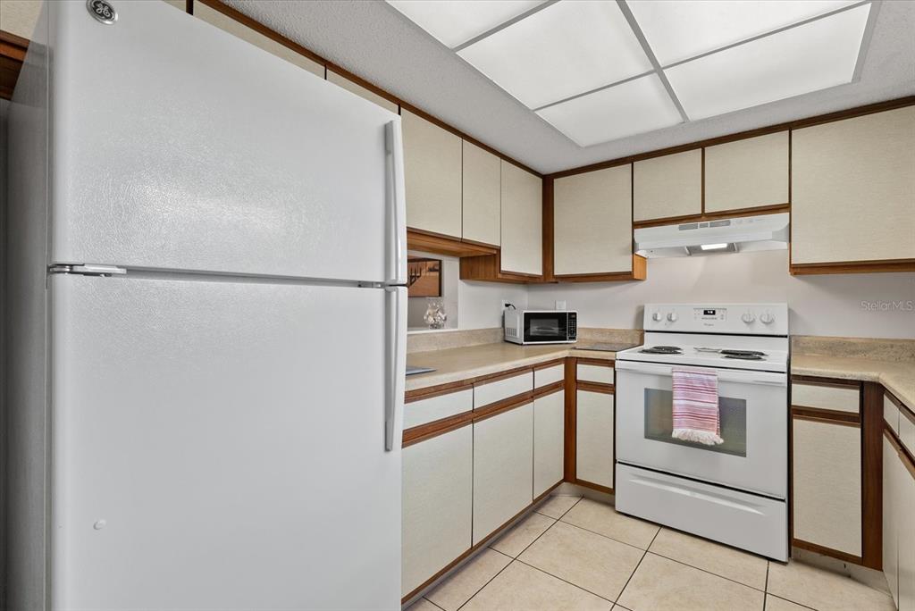 1531 Placida Road, Unit 204 Englewood, FL 34223 - Photo 11 of 47 a kitchen with white cabinets and white appliances