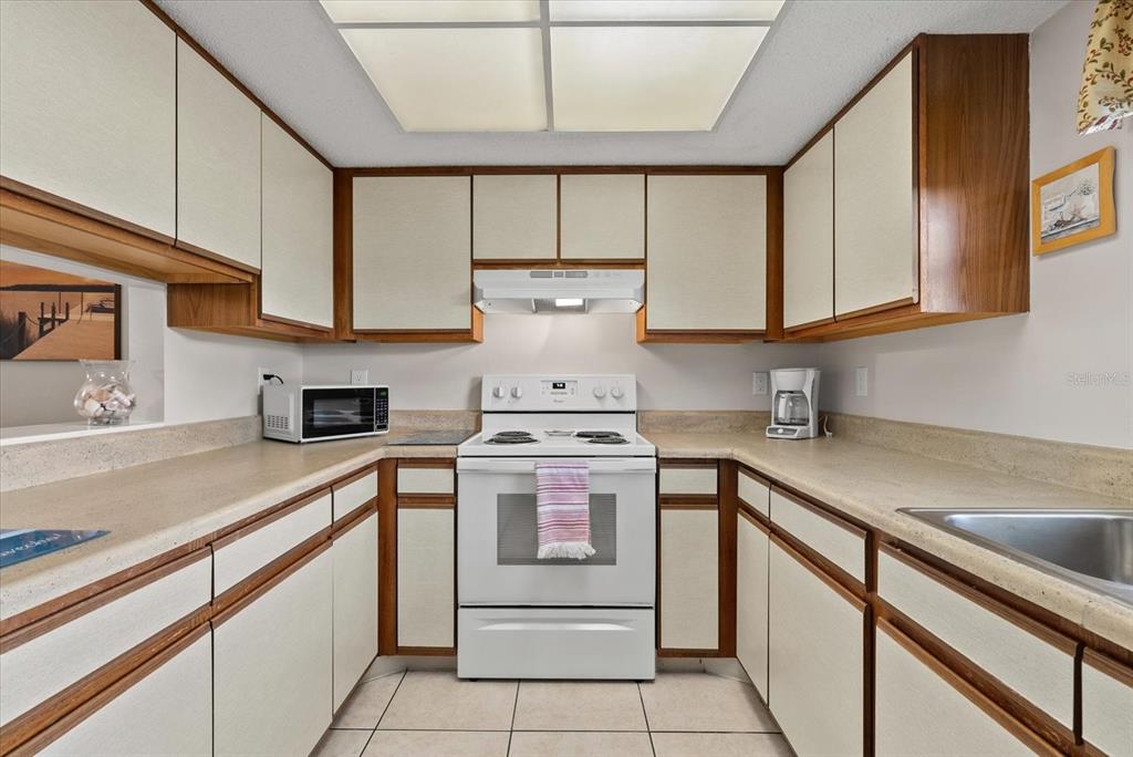 1531 Placida Road, Unit 204 Englewood, FL 34223 - Photo 12 of 47 a kitchen with a stove cabinets and a sink