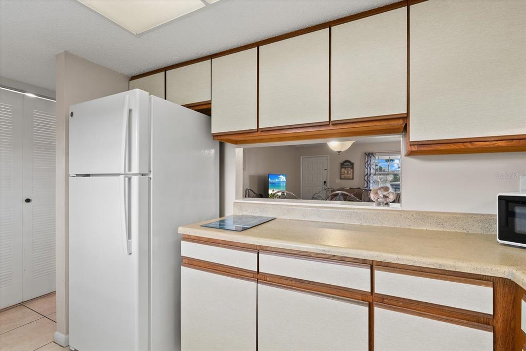 1531 Placida Road, Unit 204 Englewood, FL 34223 - Photo 14 of 47 a kitchen with a refrigerator and cabinets