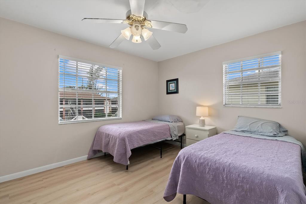 1531 Placida Road, Unit 204 Englewood, FL 34223 - Photo 23 of 47 a bedroom with two beds a chandelier and a window