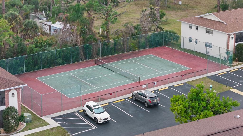 1531 Placida Road, Unit 204 Englewood, FL 34223 - Photo 36 of 47 a view of a tennis ground with large trees