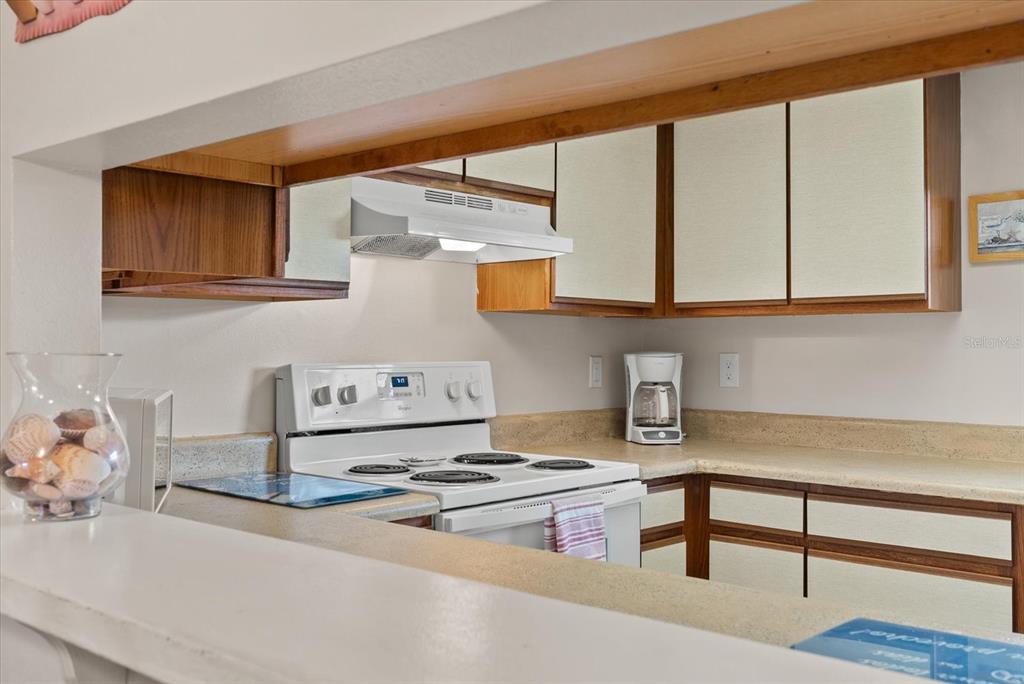 1531 Placida Road, Unit 204 Englewood, FL 34223 - Photo 9 of 47 a kitchen with stainless steel appliances granite countertop a stove a sink and a microwave