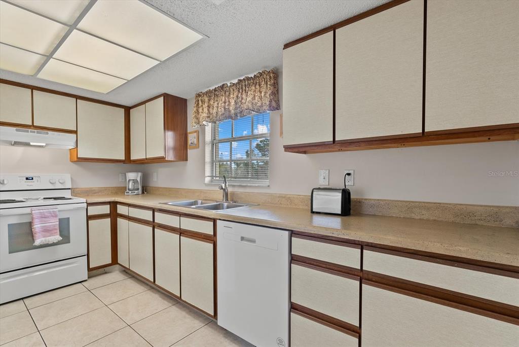 1531 Placida Road, Unit 204 Englewood, FL 34223 - Photo 10 of 47 a kitchen with a sink stove and cabinets