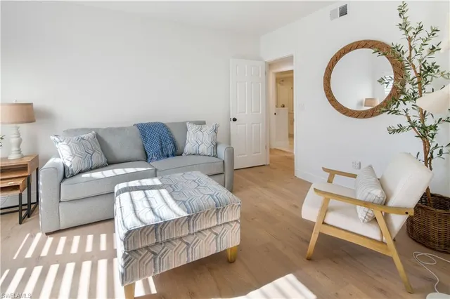 a living room with furniture a mirror and a lamp