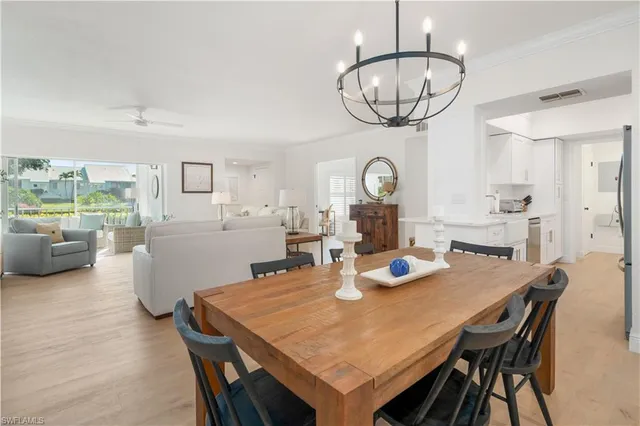 a view of a dining room with furniture a chandelier and wooden floor