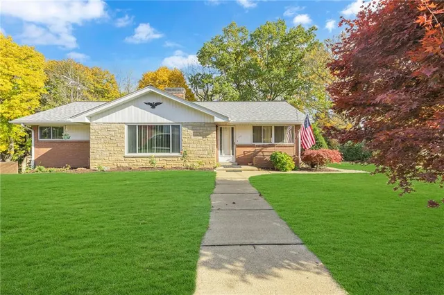 a front view of a house with a garden and yard