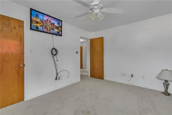 an empty room with windows and ceiling fan