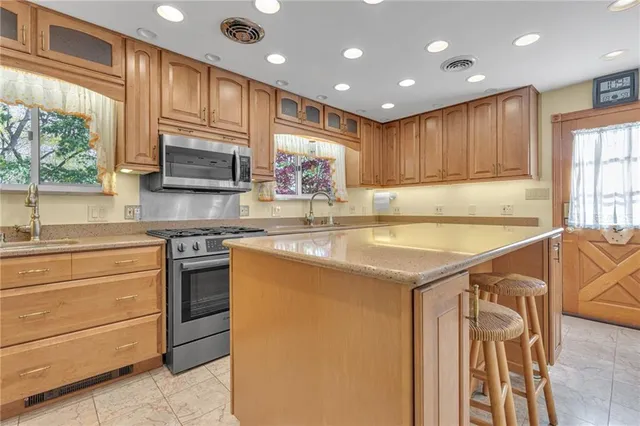 a kitchen with stainless steel appliances granite countertop a refrigerator and a sink