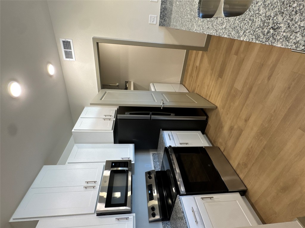 691 Union Chapel Road, Unit B2 Cedar Creek, TX 78612 - Photo 14 of 26 Kitchen featuring stainless steel appliances, stone counters, white cabinetry, and light wood-style flooring