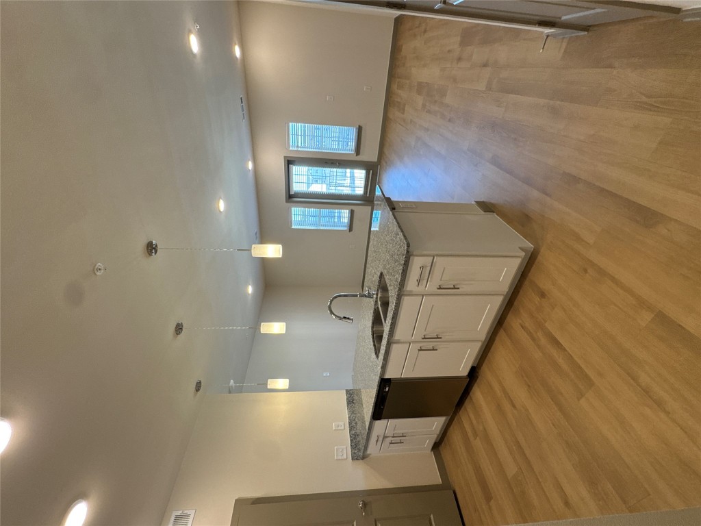 691 Union Chapel Road, Unit B2 Cedar Creek, TX 78612 - Photo 26 of 26 Kitchen with light stone countertops, pendant lighting, light wood finished floors, open floor plan, and white cabinets
