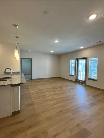 an empty room with windows and ceiling fan