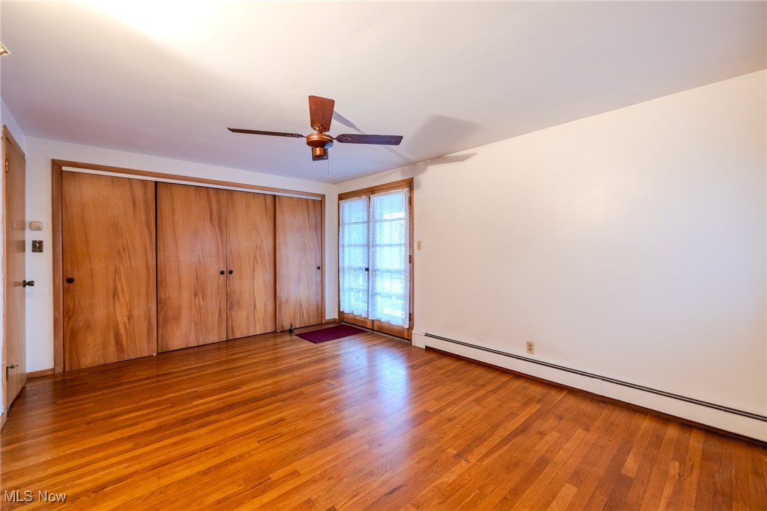 1950 Rush Road Wickliffe, OH 44092 - Photo 11 of 50 Unfurnished bedroom with a baseboard radiator, light wood-style floors, a closet, and a ceiling fan