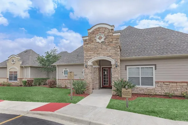 a front view of a house with a garden and plants