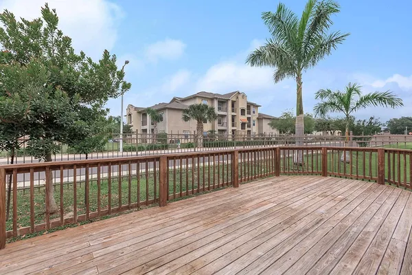 a view of a balcony with wooden floor and fence