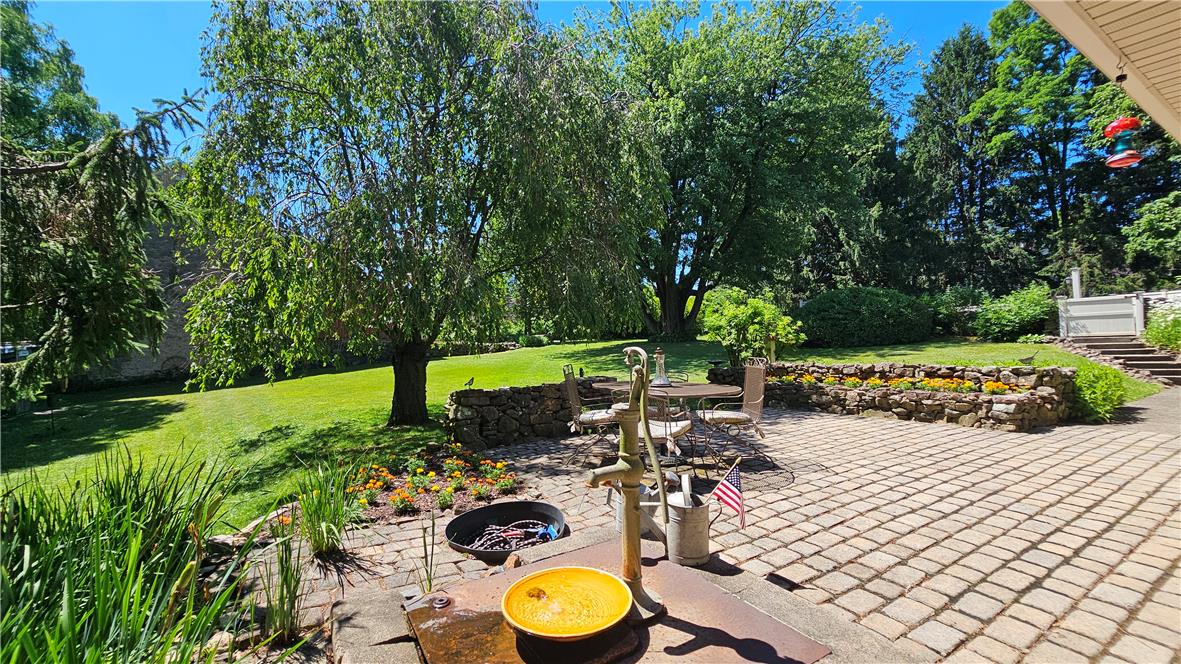 585 Buttermilk Road Hellertown, PA 18055 - Photo 38 of 82 A tranquil outdoor living space unfolds with a brick patio, lush lawn, and mature trees.
