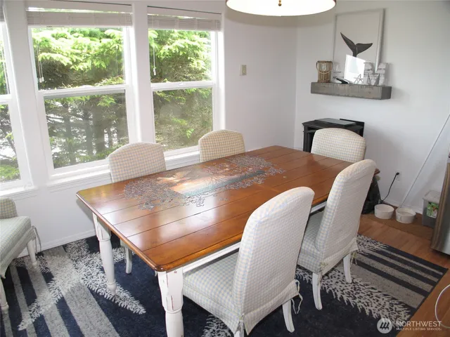 a kitchen with stainless steel appliances granite countertop a table chairs refrigerator and sink