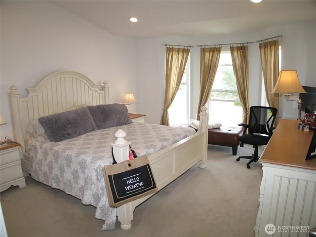 a spacious bedroom with a bed and a large window