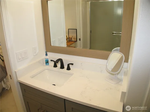 a bathroom with a toilet sink vanity tub and mirror